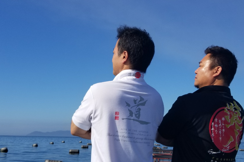 海を眺める株式会社ヒラオ代表の中岡(左)とマルエイ水産株式会社の大野社長(右)