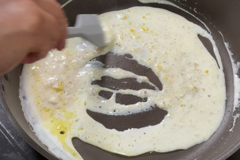 フライパンで生クリームとレモンを合わせ、クリームソースを作る工程