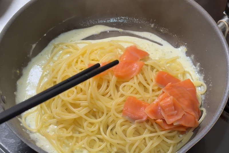レモンクリームソースにパスタとスモークサーモンを加えて絡める